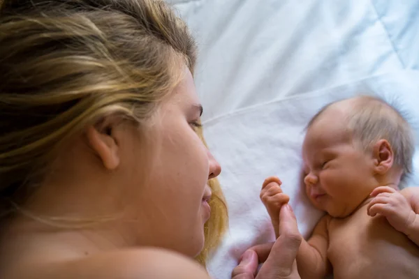 Mutter schaut ihr neugeborenes Baby sanft an — Stockfoto
