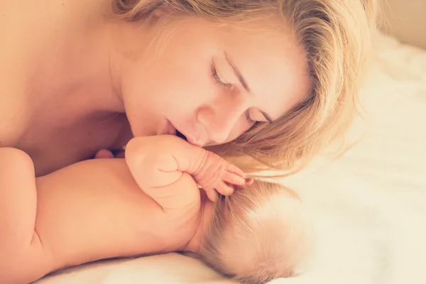 Mom gently kissisng newborn baby — Stock Photo, Image