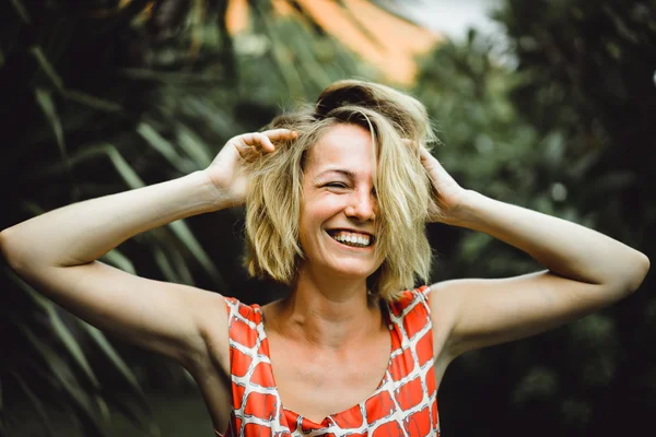 Chica rubia contra las palmeras tropicales — Foto de Stock