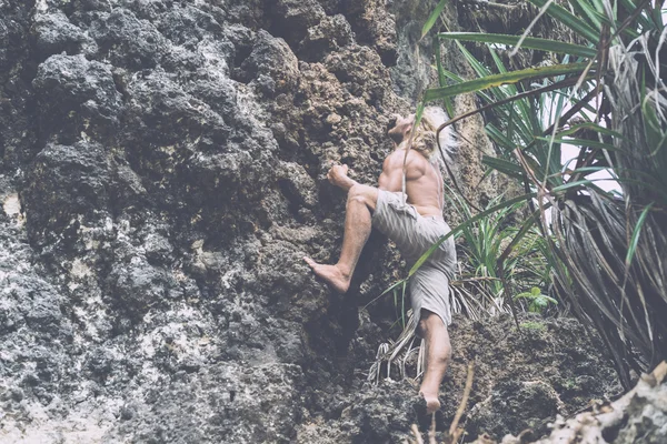 Brutaler Mann klettert auf Felsen — Stockfoto