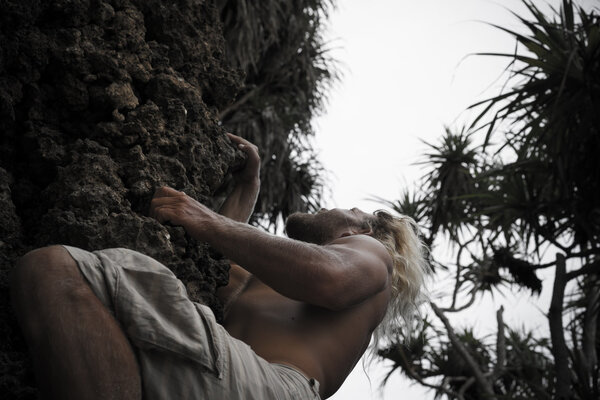 brutal man climbing up the rock 