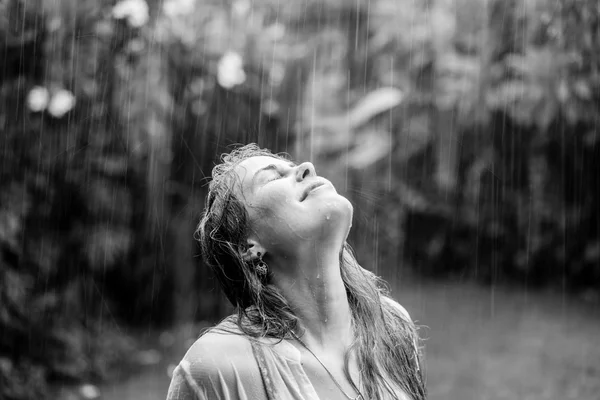Hermosa chica de pie en la lluvia tropical — Foto de Stock