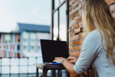 Açık havada bir kafede çalışıyor