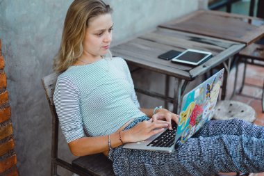 Açık havada bir kafede çalışıyor