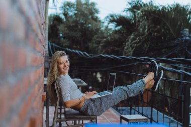 Açık havada bir kafede çalışıyor