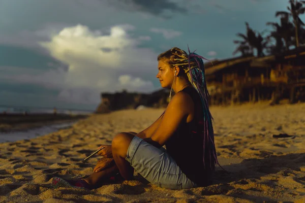 Hipster vrouw op het strand kijken naar de zonsondergang — Stockfoto