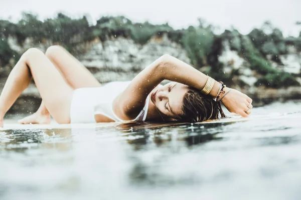 Красивая девушка в океане Серфинг под дождем — стоковое фото