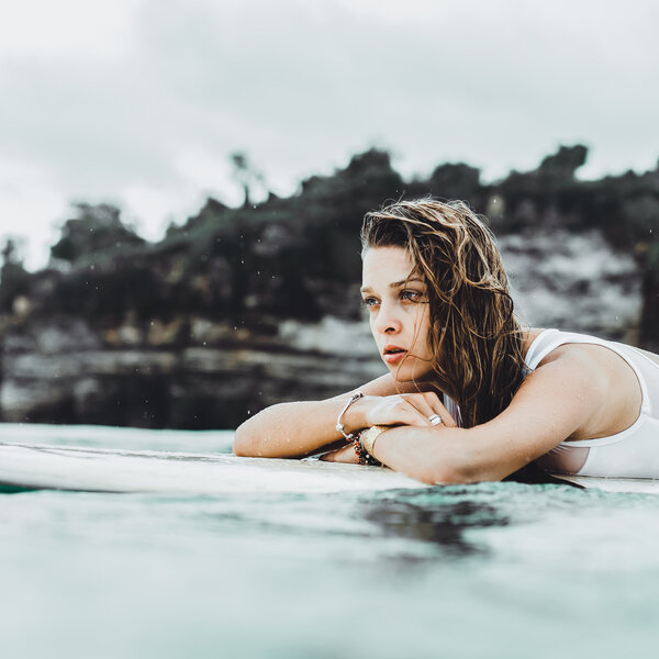 beautiful girl in the ocean Surf in the rain