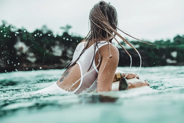 美丽的女孩在海洋冲浪在雨中 — 图库照片