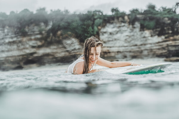 beautiful girl in the ocean Surf in the rain