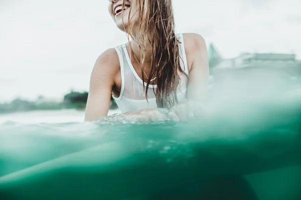 Piękna dziewczyna w ocean Surf w deszczu — Zdjęcie stockowe