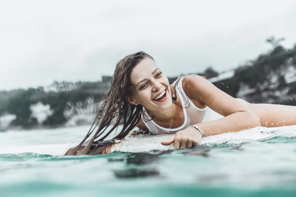Красива дівчина в океані Серфінг під дощем — стокове фото