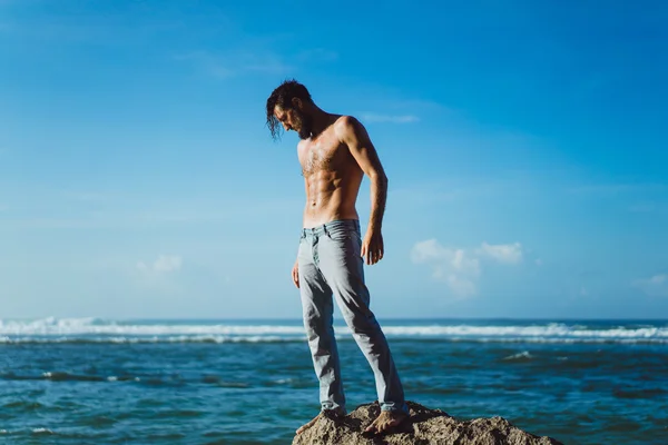 Человек на пляже на фоне океана — стоковое фото