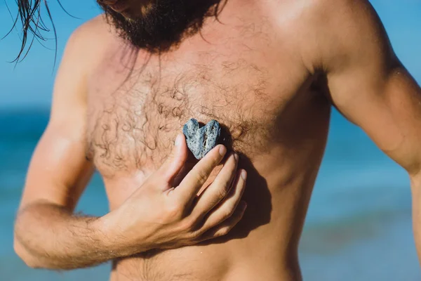 Uomo in possesso di pietra a forma di cuore — Foto Stock