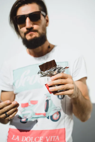 Hombre barbudo feliz come chocolate —  Fotos de Stock