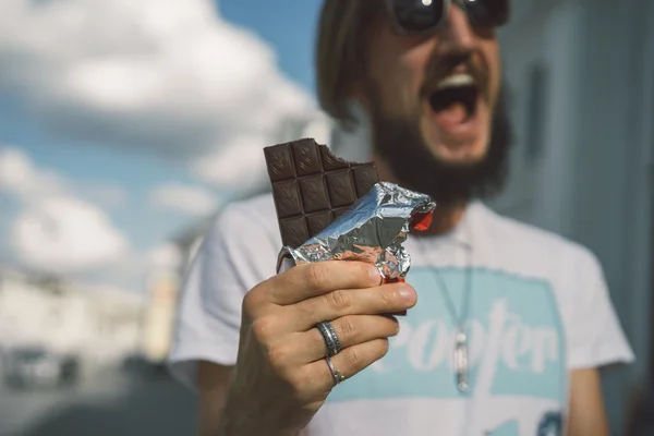 Happy bearded man eats chocolate — Stock Photo, Image