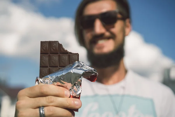 Happy bearded man eats chocolate — Stock Photo, Image