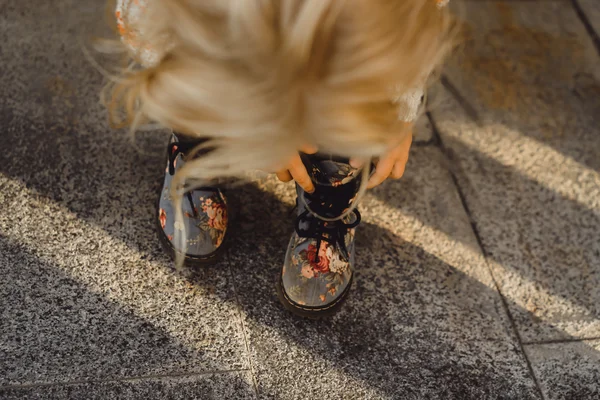 Mała dziewczynka stawia na buty — Zdjęcie stockowe