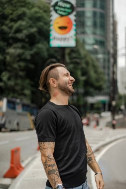 Kuala Lumpur 'da sokakta gülümseyen çekici, mutlu bir adam. Şehir erkekleri, giyim tarzı. Sabun köpükleri havada uçuşuyor..