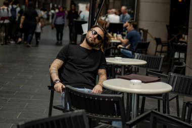 Kuala Lumpur 'da sokakta gülümseyen çekici, mutlu bir adam. Şehir erkekleri, giyim tarzı. Sabun köpükleri havada uçuşuyor..