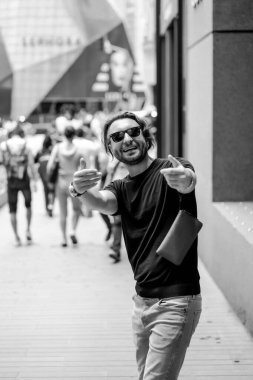 Kuala Lumpur 'da sokakta gülümseyen çekici, mutlu bir adam. Şehir erkekleri, giyim tarzı. Sabun köpükleri havada uçuşuyor..