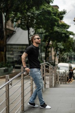 Kuala Lumpur 'da sokakta gülümseyen çekici, mutlu bir adam. Şehir erkekleri, giyim tarzı. Sabun köpükleri havada uçuşuyor..