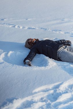 Buz pateni, genç kadın buz pateni öğreniyor, düşüyor, karda oturuyor, kış sporları, kar, kış eğlencesi.