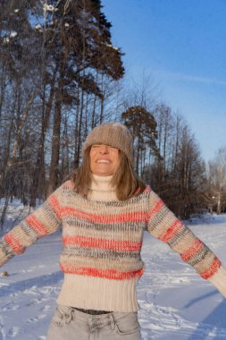 Güzel, modaya uygun, mutlu, kışın gülümseyen kadın portresi, kış şapkalı kadın, kar. Kış anlarının tadını