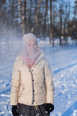Güzel, modaya uygun, mutlu, kışın gülümseyen kadın portresi, kış şapkalı kadın, kar. Kış anlarının tadını