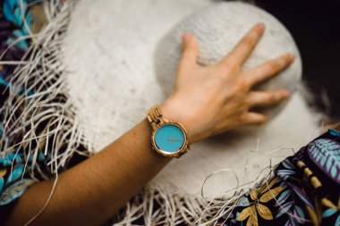 Bronzlaşmış bir kadının kolundaki mekanik kol saati.