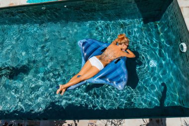 young woman in the pool on an inflatable mattress