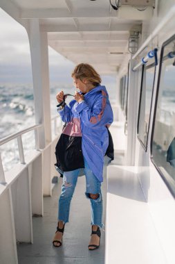 Açık denizdeki bir yatın güvertesinde genç bir kadın. seyahat