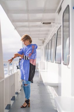 Açık denizdeki bir yatın güvertesinde genç bir kadın. seyahat