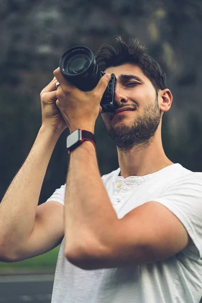 Professional photographer taking picture. young man with a camera. a man takes a photo with a professional camera in nature.