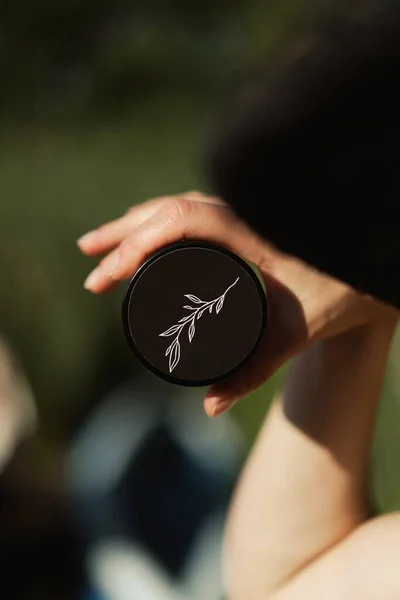 a jar of powder in the hands of a woman.