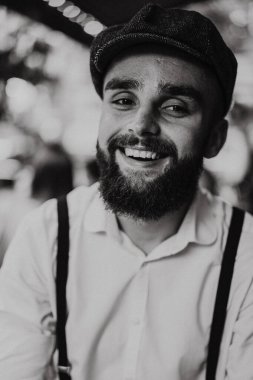 Caddedeki kafede elinde bir bardak şarapla sakallı genç bir adam. Şehirde beyaz gömlekli ve pantolon askısı takan romantik bir adam. Peaky Blinders. eski fasyon retro.