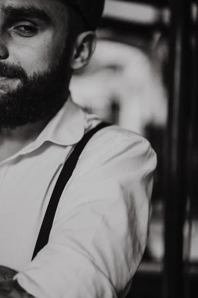 一个留着胡子的年轻人在街上的咖啡店里喝了杯酒 城市里穿着白衬衫帽和吊袜带的浪漫男人 小眼镜片 旧筋膜复位 — 图库照片