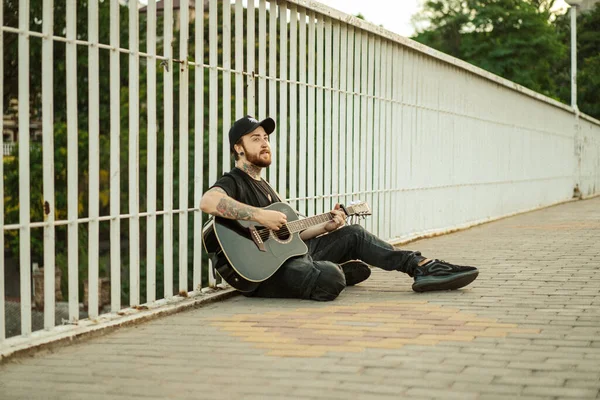 若い男ストリートミュージシャンがギターと歌を演奏します ストリートミュージシャン — ストック写真