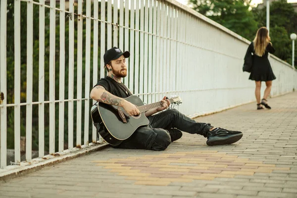 若い男ストリートミュージシャンがギターと歌を演奏します ストリートミュージシャン — ストック写真