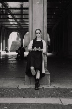 Sonbaharda New York Manhattan Central Park, göl üzerinde köprü. Genç bir kadın New York 'ta bir sonbahar parkında yürüyor..