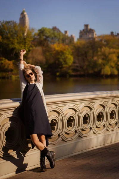 秋にはニューヨーク マンハッタン セントラル パーク 湖にかかる橋 若い女性がニューヨークの秋の公園を歩き — ストック写真