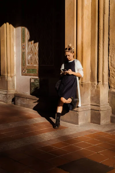 Sonbaharda New York Manhattan Central Park, göl üzerinde köprü. Genç bir kadın New York 'ta bir sonbahar parkında yürüyor..