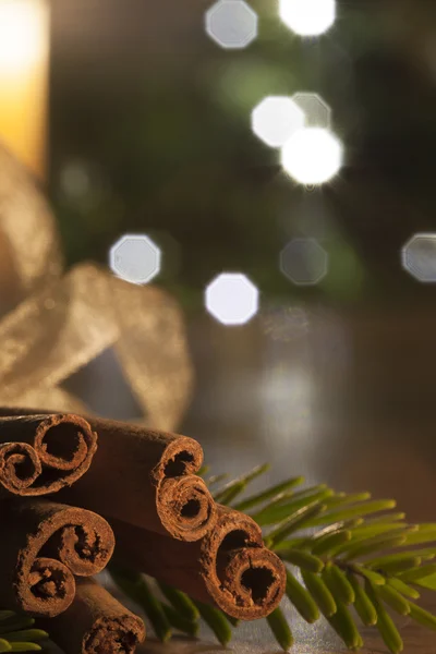 Skořice a zapálil svíčku na dřevěný stůl infront Vánoce — Stock fotografie
