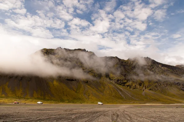 Coches cruzando la montaña con nubes en el cielo — Foto de Stock