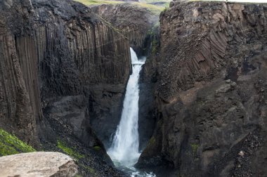 Kayalar ve çim çevresinde görkemli şelaleler