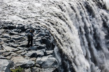 Kayaların etrafında ve insanlar ile görkemli şelaleler