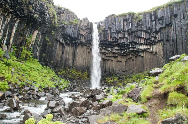 Majestuosas cascadas con rocas y hierba alrededor — Foto de Stock