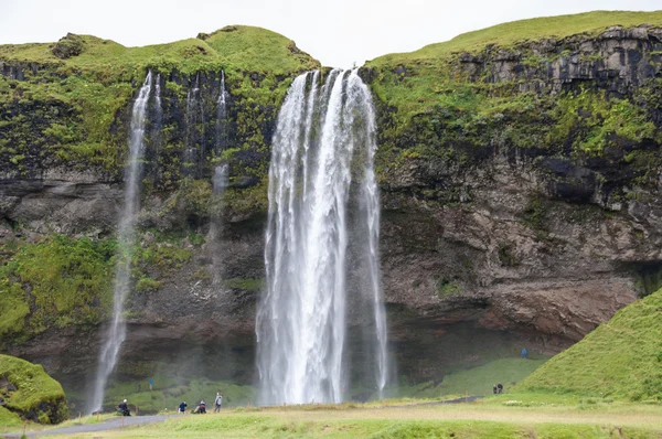 Majestätiska vattenfall med stenar och gräs runt — Stockfoto