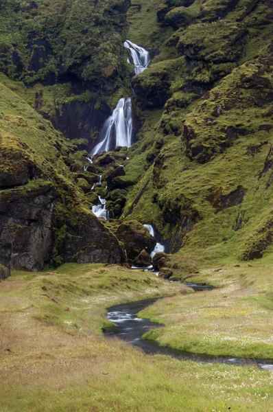 Cachoeiras majestosas com rochas e grama ao redor — Fotografia de Stock