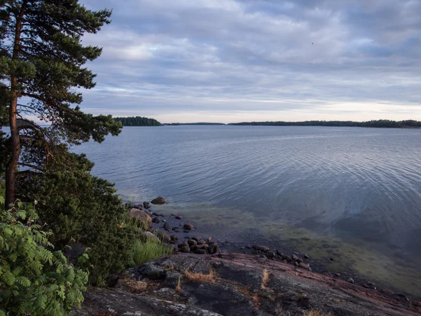 Морской пейзаж с камнями и небо с облаками — стоковое фото